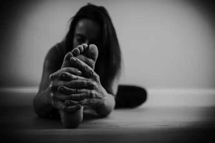 grayscale photo of woman covering her face with her hand