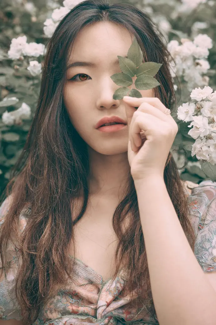 woman in white floral dress holding white flower